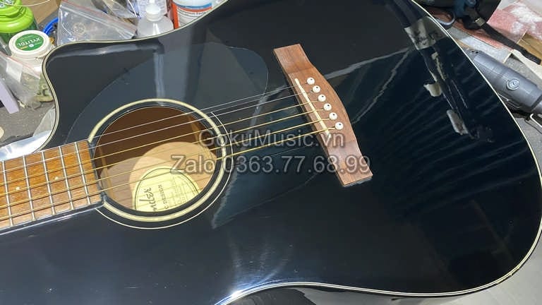 Kỹ thuật viên Goku Music bảo dưỡng căn chỉnh đàn guitar trước khi đăng bán